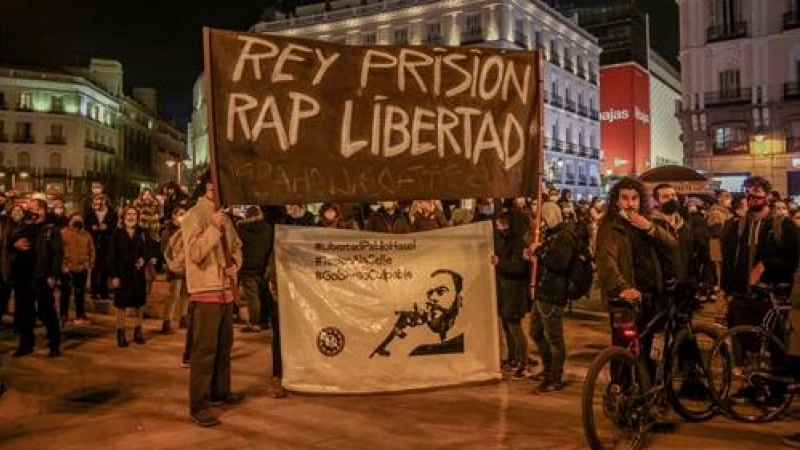 Varias personas sujetan una pancarta en la que se lee: `Rey prisión, Rap Libertad´ durante una manifestación contra el encarcelamiento del rapero y poeta Pablo Hasel.