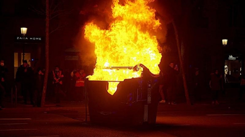 Contenedor ardiendo durante los disturbios por el encarcelamiento de Pablo Hasél en Barcelona.   FOTOMOVIMIENTO / FLICKR