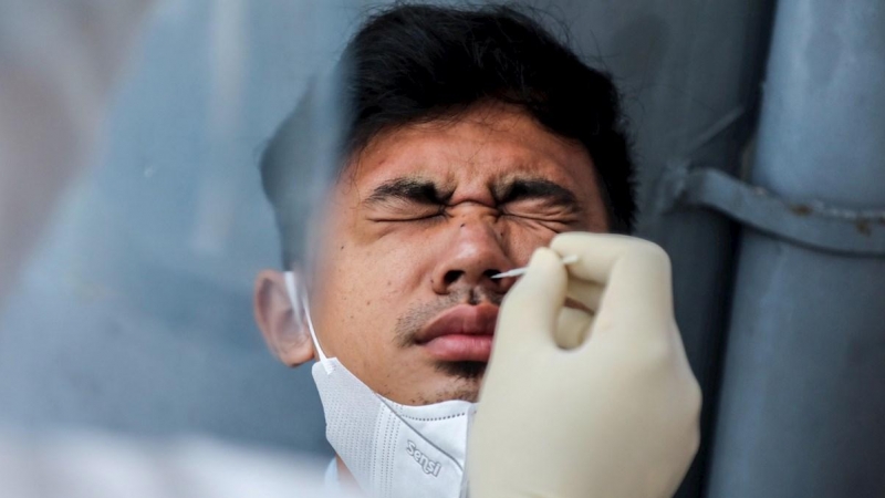 Un sanitario realiza un test de la covid-19 a un hombre en Madan, Indonesia.