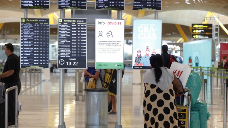 Pasajeros cerca de páneles informativos en la terminal T4 del aeropuerto Adolfo Suárez Madrid-Barajas, en Madrid. E.P./Jesús Hellín
