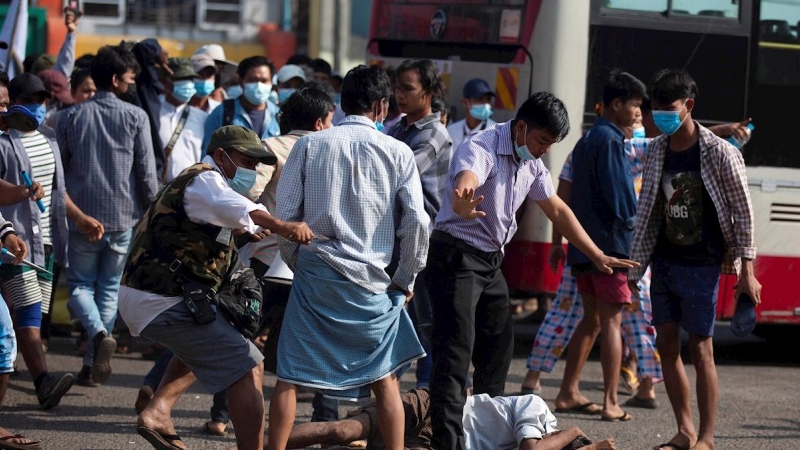 Un residente Yangon (Myanmar) cae al suelo mientras simpatizantes promilitares atacan a los residentes con honda y proyectiles