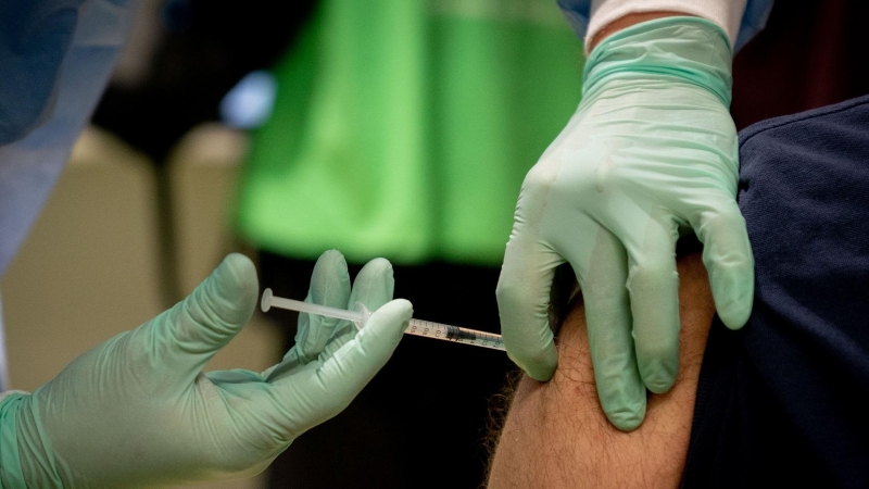 Un sanitario administra una vacuna contra la covid en  Berlín, Alemania