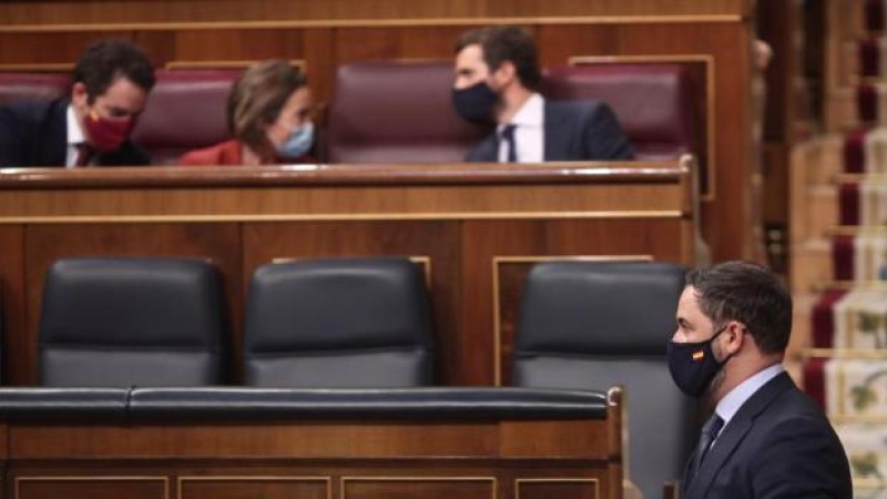 El presidente de Vox, Santiago Abascal, pasa por delante del (I-D) diputado del PP, Teodoro García Egea; la portavoz del PP en el Congreso de los Diputados, Cuca Gamarra; y el presidente del PP, Pablo Casado, durante la segunda sesión del pleno.