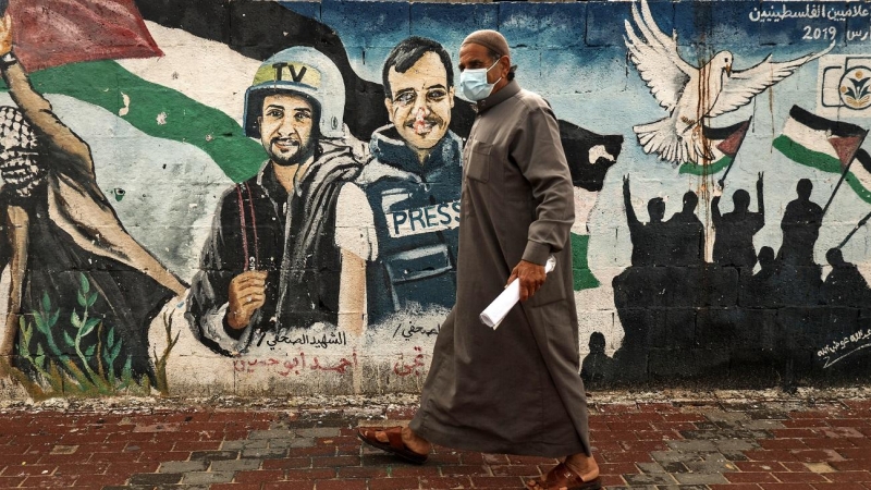 Un palestino pasa frente a un mural de periodistas asesinados en 2014 entre Hamas e Israel en Gaza.