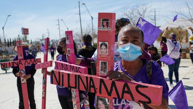 Mujeres sostienen cruces en la que se lee: 'Ni una más' en Ciudad Juarez, México
