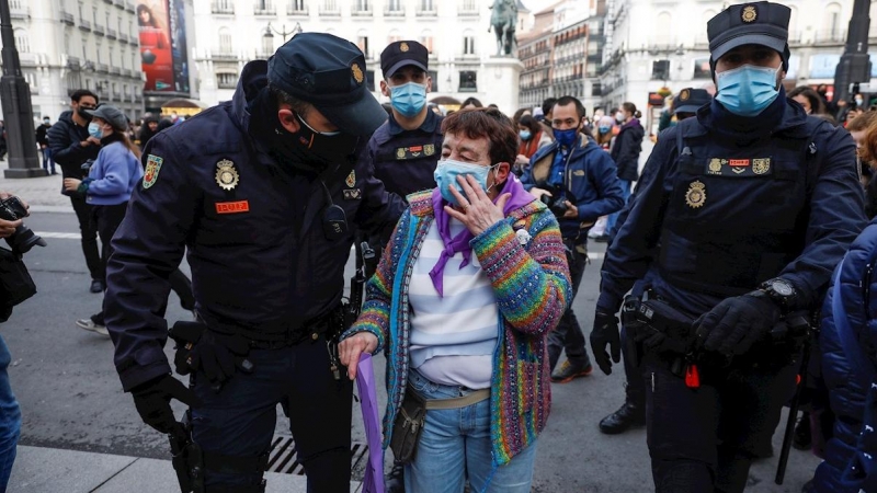 Agentes de la policía socorren a una mujer herida durante la concentración convocada por el Sindicato de Estudiantes y la asociación Libres y Combativas, por el Día de la Mujer hoy lunes en la Puerta del Sol de Madrid.