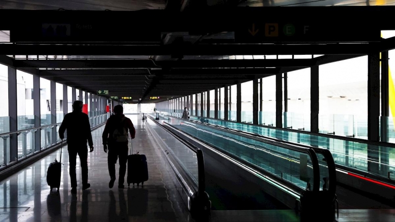 Dos pasajeros cruzan una de las terminales del Aeropuerto Adolfo Suárez Madrid-Barajas.