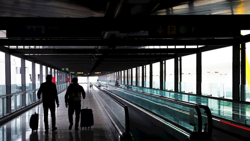 Dos pasajeros cruzan una de las terminales del Aeropuerto Adolfo Suárez Madrid-Barajas.