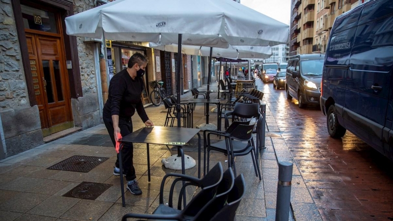 Un camarero de una tabernera de Vitoria monta la terraza de su bar.