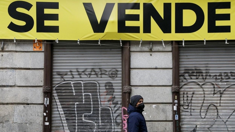 Un joven pasa por delante de un local cerrado, en venta, en el centro de Madrid. REUTERS/Susana Vera