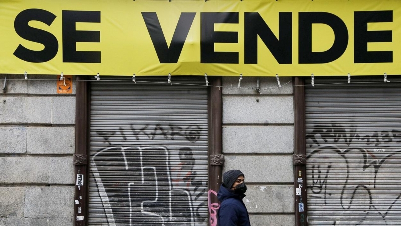 Un joven pasa por delante de un local cerrado, en venta, en el centro de Madrid. REUTERS/Susana Vera