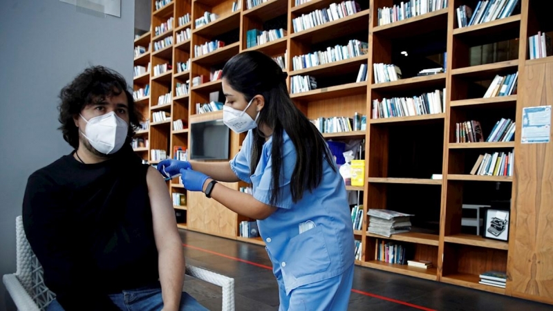 Una profesional sanitaria administra la vacuna contra la covid-19 a un ciudadano en los pasillos del Hotel SB Plaza Europa, ubicado cerca del recinto de Fira de Barcelona de L'Hospitalet de Llobregat.