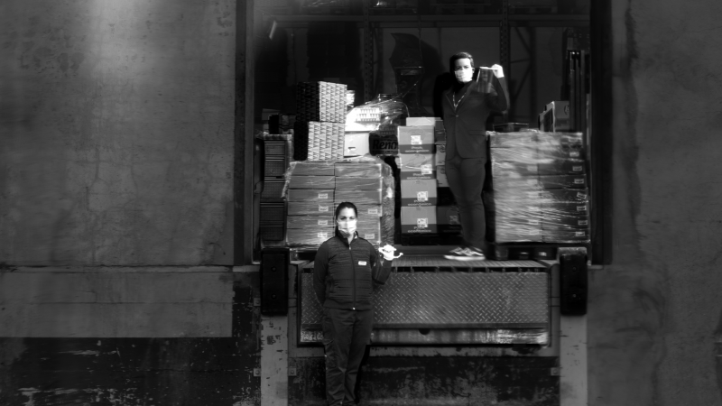 Dos trabajadoras de un almacén posan ante la cámara protegidas con mascarillas. - Isabel Muñoz