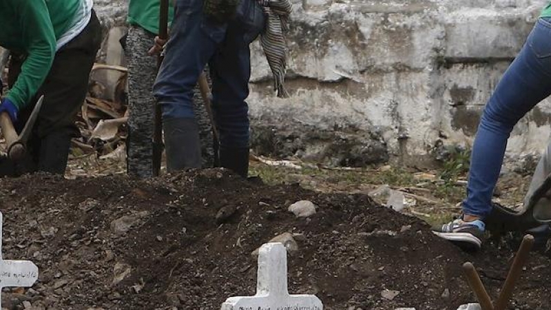 Un grupo de trabajadores ayudan a excavar durante una jornada de exhumación en el cementerio del municipio de Dabeiba el 11 de marzo de 2021, departamento de Antioquia (Colombia).