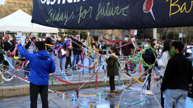 Fridays For Future Barcelona prepara una performance amb una xarxa en el dia d'Acció Global pel Clima, a Arc de Triomf, per denunciar que el sistema actual els 'roba' el temps davant de l'emergència climàtica. 19 de març del 2021.