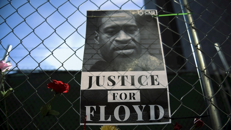 Imagen de archivo de un cartel conuna fotografía de George Floyd acompañada de mensajes de protesta y flores, en Mineápolis. - EFE