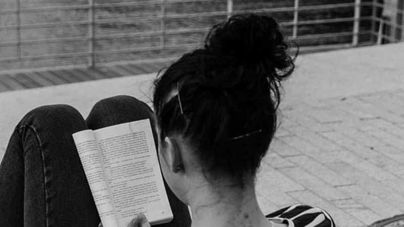 Mujer leyendo en un banco.