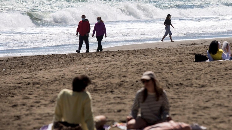 Varias personas pasean este domingo por la playa de La Misericordia aprovechando el buen tiempo