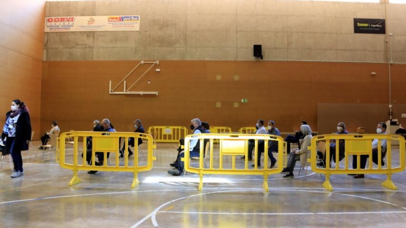 Persones que han rebut la vacuna de la Covid esperen assegudes uns 15 minuts al poliesportiu L'Olivera de Sant Boi de Llobregat, convertit en punt de vacunació.