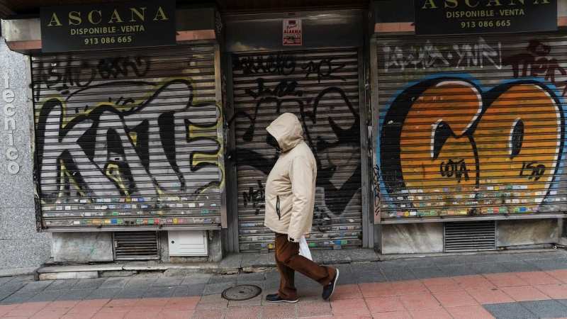 Una persona pasa por delante de un comercio cerrado, en Madrid. REUTERS/Susana Vera