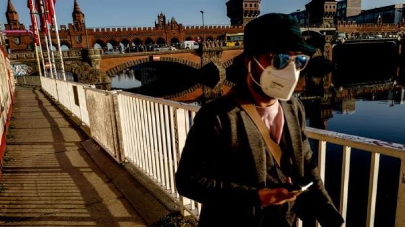 Un hombre usa máscara mientras camina junto al puente Oberbaum en Berlín, Alemania, 02 de marzo de 2021.