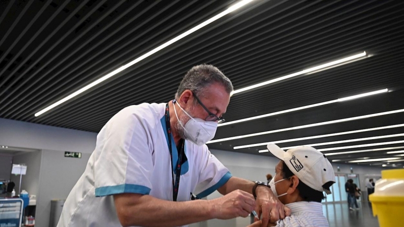 Un sanitario vacuna a una persona en el estadio Wanda Metropolitano en Madrid, que acoge este martes el inicio de la vacunación con Astrazeneca para la población general de 60 a 65 años, que toman el relevo de los mayores de 80 años que viven en sus domi