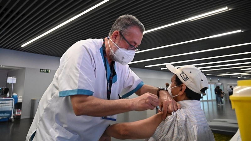 Un sanitario vacuna a una persona en el estadio Wanda Metropolitano en Madrid, que acoge este martes el inicio de la vacunación con Astrazeneca para la población general de 60 a 65 años, que toman el relevo de los mayores de 80 años que viven en sus domi