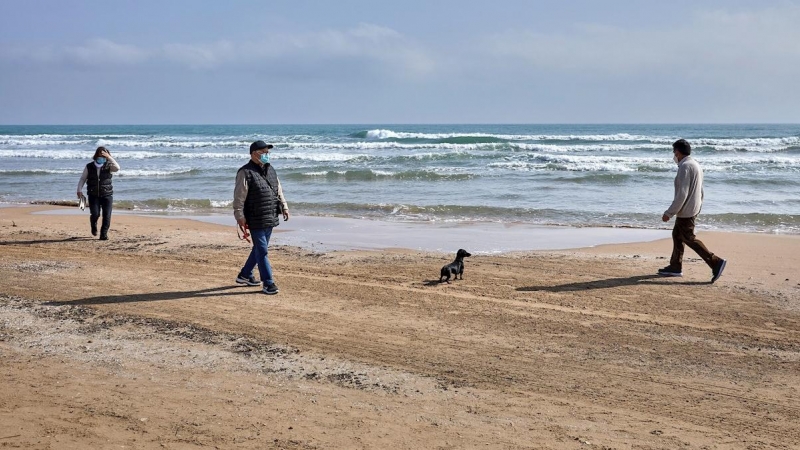Varias personas pasean por la playa de Gandía, València.