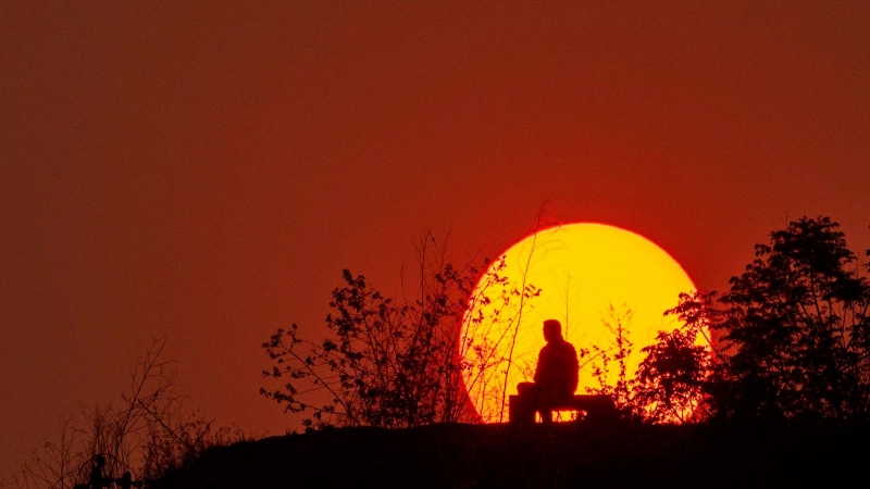 Una persona disfruta de la espectacular puesta de sol en un parque de Katmandú, en Nepal.