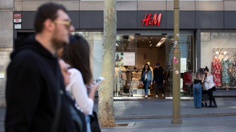 Varias personas pasan frente a una tienda de H&M en Barcelona. E.P./David Zorrakino