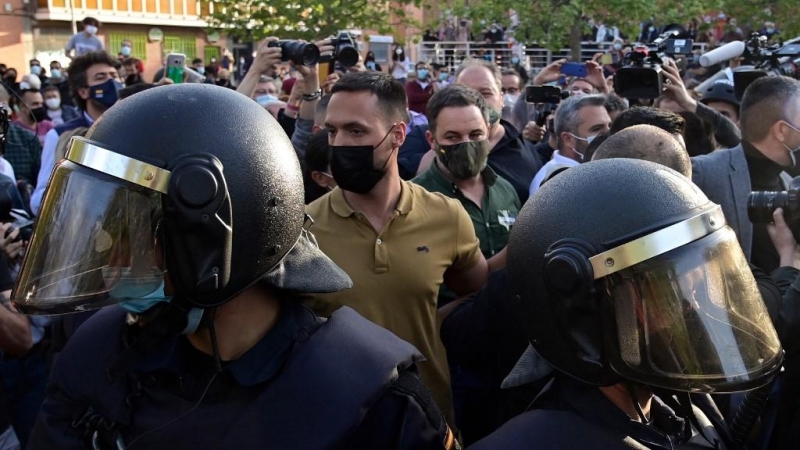 El líder de Vox, Santiago Abascal, rodeado por la Policía a su llegada al mitin del partido de ultraderecha en Vallecas, Madrid.