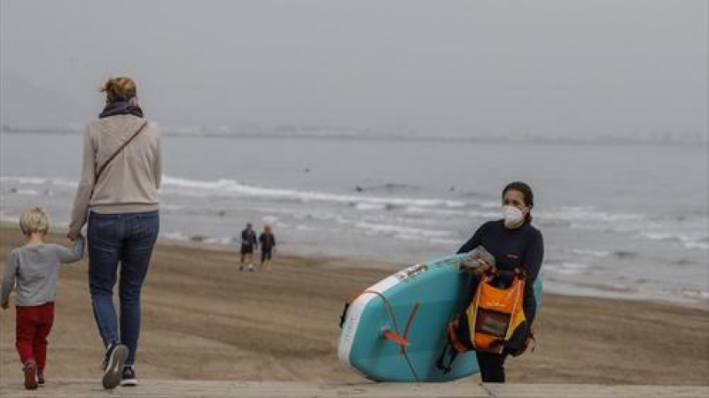 Una mujer sale con mascarilla de la playa la Malvarrosa en Valencia, Comunidad Valenciana (España), a 1 de abril de 2021