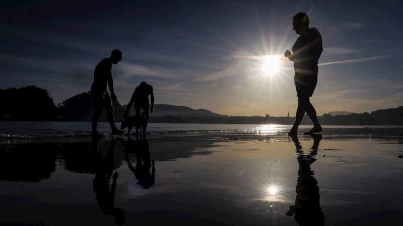 Varias personas pasean en la playa de Ondarreta de San Sebastián.