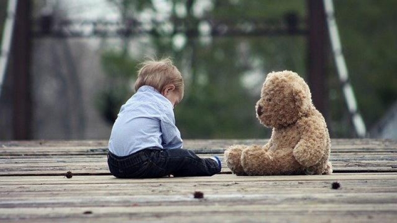 Foto de archivo de un niño con un oso de peluche.