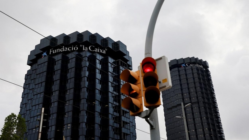Un semáforo en rojo delante de los edificios centrales de Caixabank en Barcelona. REUTERS/Nacho Doce