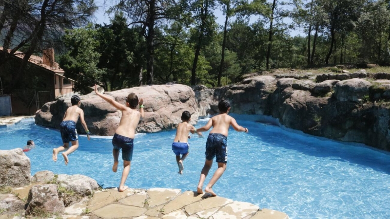 Pla general dels nens tirant-se a la piscina de la casa de colònies. Imatge del 25 de juny del 2020.