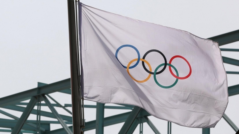 La bandera nacional china ondea junto a una bandera olímpica en el Comité Organizador de los Juegos Olímpicos y Paralímpicos de Invierno de 2022 en Beijing.