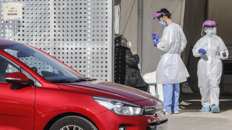 Imagen de archivo de profesionales sanitarios realizando pruebas PCR a las personas de los vehículos que se acercan. - Europa Press