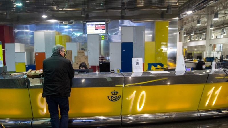 16/03/2021. Imagen de archivo de un cliente siendo atendido en una oficina de Correos, en Madrid. - EUROPA PRESS