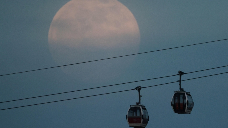 La luna llena, también conocida como Supermoon, se eleva sobre el teleférico de Emirates Air Line en Londres