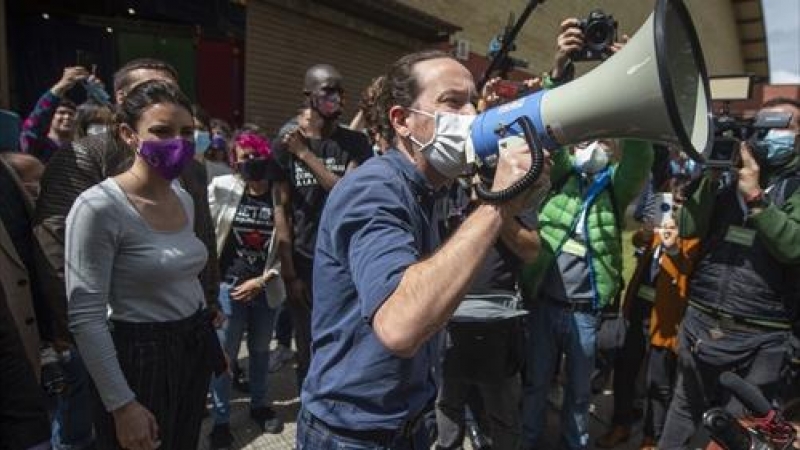 La ministra de Igualdad y el candidato de Unidas Podemos a la Presidencia de la Comunidad, Pablo Iglesias con un megáfono se dirige al público durante un acto del partido en el Polideportivo municipal Cerro Buenavista de Getafe, a 27 de abril de 2021, en