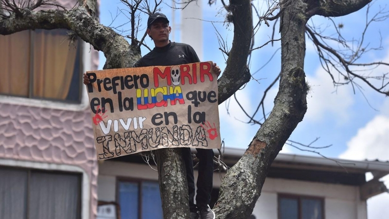 01/05/2021. Un hombre sostiene un cartel en nueva jornada de protesta contra la reforma tributaria defendida por el presidente de Colombia. - EFE