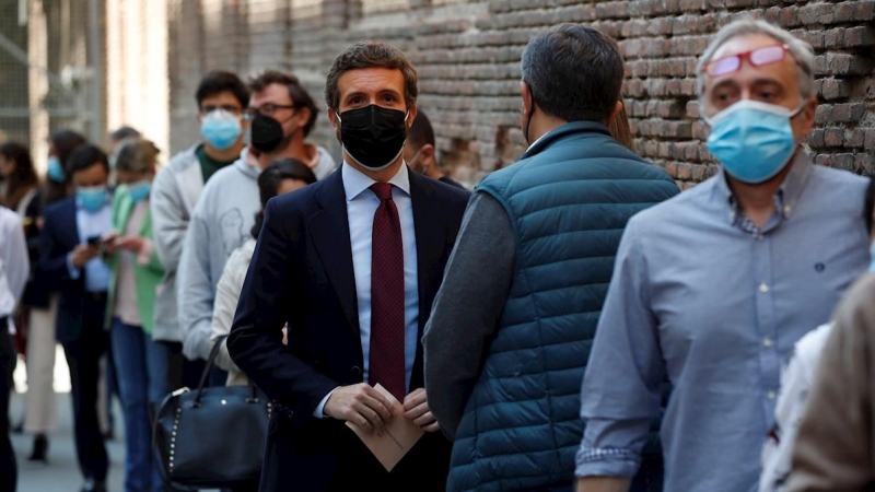 El presidente del PP, Pablo Casado, hace cola a las puertas del Colegio Nuestra Señora del Pilar de Madrid, donde ha acudido este martes para votar.