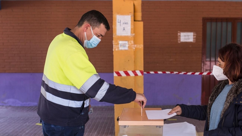 Un trabajador ejerce su derecho a voto a la hora de comer en el Colegio Público Asturias en el distrito Puente de Vallecas