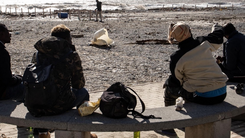 Un grupo de migrantes se sienta junto a la orilla en Ventimiglia el 3 de octubre de 2020.
