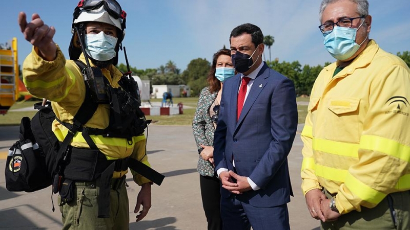 El presidente de la Junta, en el helipuerto de la Cartuja, en Sevilla, con personal del Infoca.