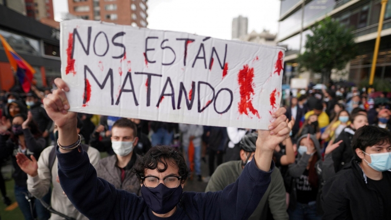Un manifestante en sostiene una pancarta en la que se lee 'Nos están matando' en Bogotá, Colombia