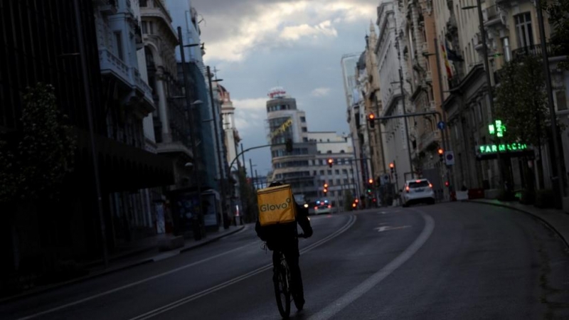 Un repartidor circula en bicicleta por la Gran Vía de Madrid, que permanece prácticamente sin coches debido a la crisis del coronavirus. Reuters/Susana Vera