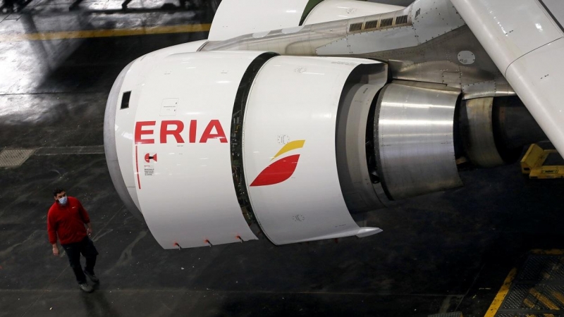 Un trabajador de Iberia, en el hangar de mantenimiento en Madrid, pasa junto al motor de un Airbus 330 que ha sido transformado de avión de pasajeros en uno de carga para enfrentar la caída de vuelos debido a la pandemia de coronavirus. REUTERS / Sergio P