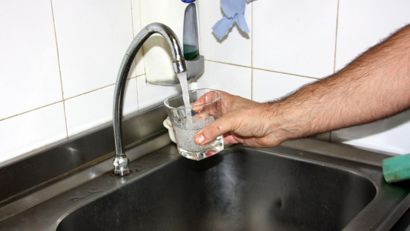 Una mà omplint un got d'aigua d'una aixeta a la Bisbal d'Empordà després de que s'hagin retirat les restriccions. 24 d'agost del 2016.